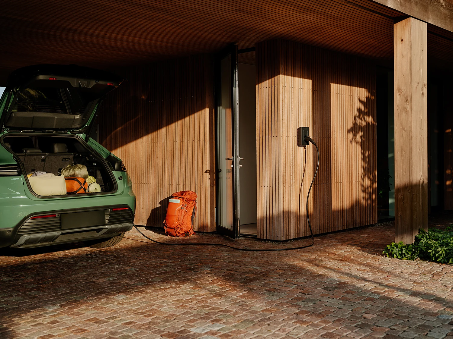 Elektrische auto die thuis laadt met een laadpaal aan de gevel
